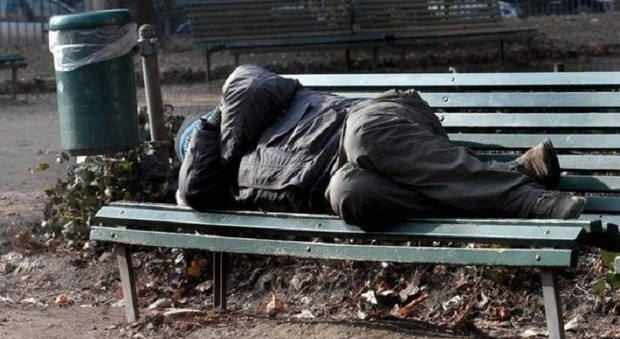 Un clochard addormentato su una panchina