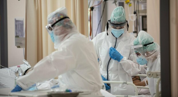 Operatori sanitari in terapia intensiva con tute protettive mediche e mascherine