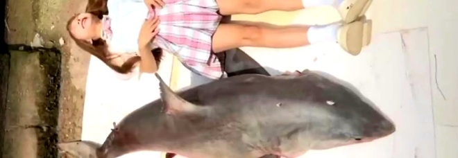 Tizi, la food blogger cinese, in posa con lo squalo bianco prima che poi ha cucinato e mangiato (immag diffuse da South China Morning Post e LaBible sui social)