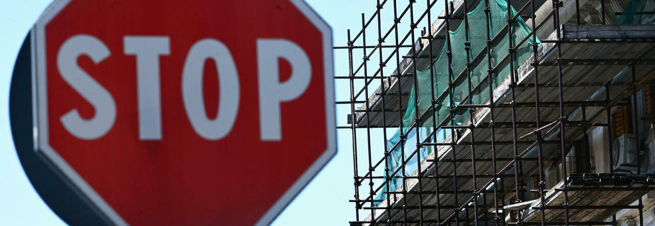 Un cartello di stop e le impalcature per la ristrutturazione edilizia al 110%